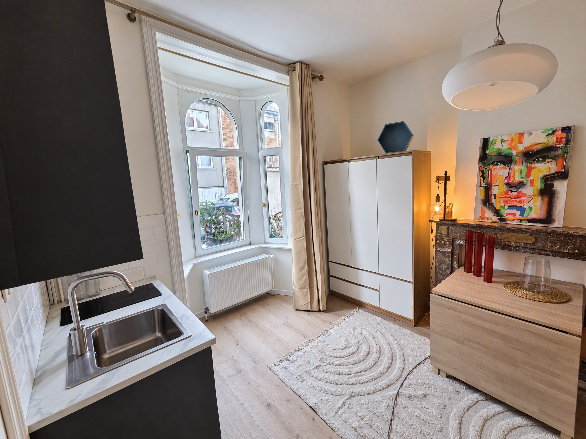 Chambre 1 · Chambre et fenêtre, avec un aperçu de la kitchenette